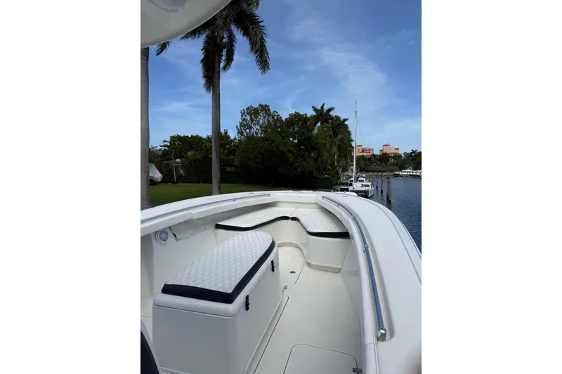Slide: The Image of 2006 Yellowfin 34 Offshore boat interior with seating, docked near palm trees and waterway. - 39