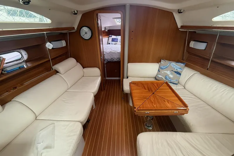 Slide: The Image of Interior of a 2012 Catalina 355 yacht with elegant wood finish and cream seating. - 13