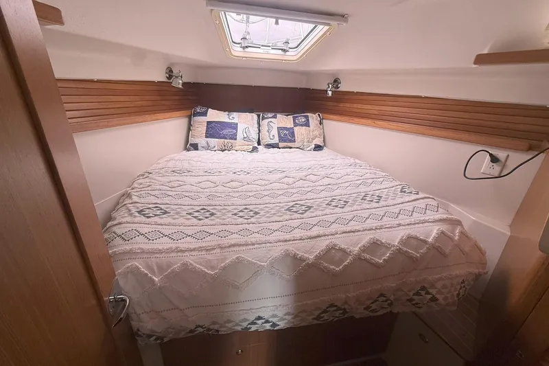 Slide: The Image of Cozy cabin bedroom in a 2012 Catalina 355 sailboat with patterned bedding and wooden accents. - 17