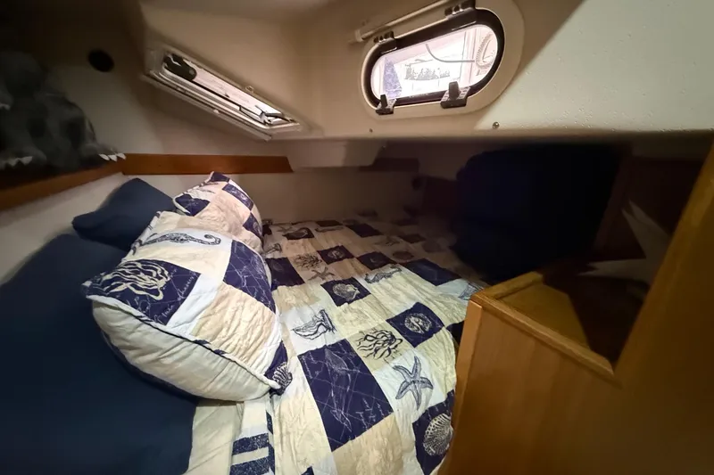 Slide: The Image of Cozy cabin interior of 2011 Catalina 355 sailboat with nautical-themed bedding. - 21