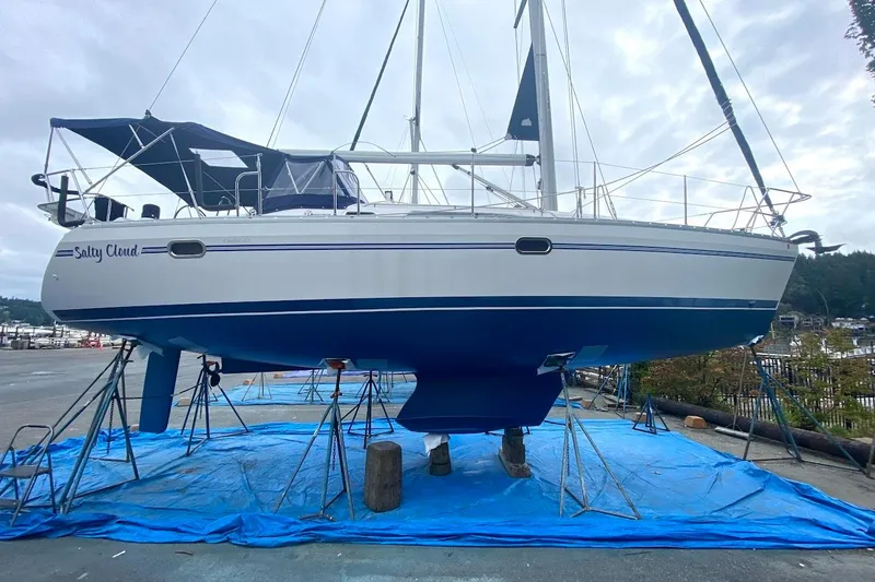 Slide: The Image of 2012 Catalina 355 sailboat named "Salty Cloud" on stands, with blue tarp underneath. - 22