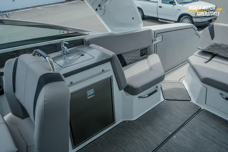 Slide: The Image of 2026 Four Winns H9 OB boat interior with seating, sink, and storage. - 26