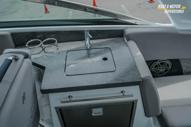 Slide: The Image of 2026 Four Winns H9 OB boat interior with sink, countertop, and cup holders. - 30