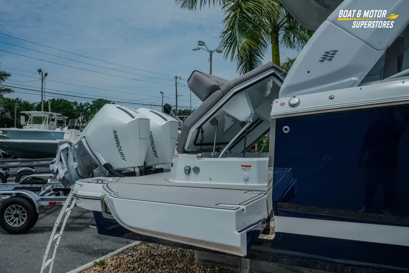 Slide: The Image of 2026 Four Winns H9 OB boat with Mercury outboard engines, displayed at a dealership. - 4
