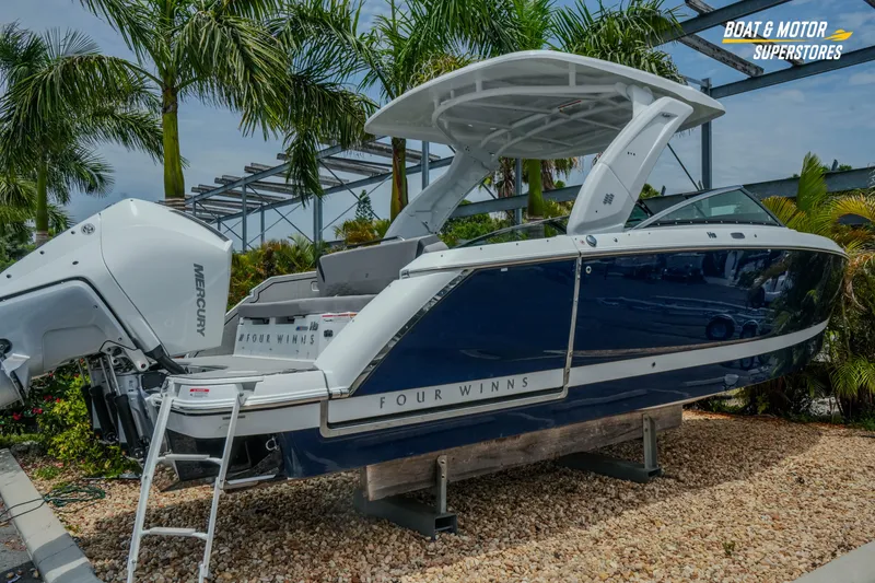Slide: The Image of 2026 Four Winns H9 OB boat with Mercury outboard engine, displayed outdoors with palm trees. - 41