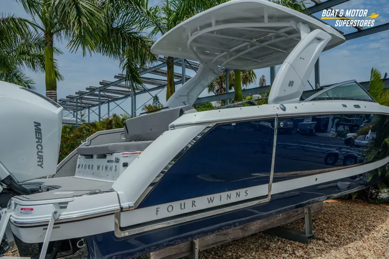 Slide: The Image of 2026 Four Winns H9 OB boat with Mercury engine, displayed outdoors near palm trees. - 42