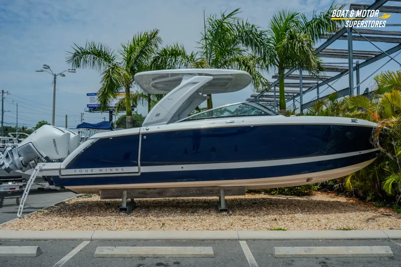 Slide: The Image of 2026 Four Winns H9 OB boat displayed outdoors with palm trees in the background. - 44
