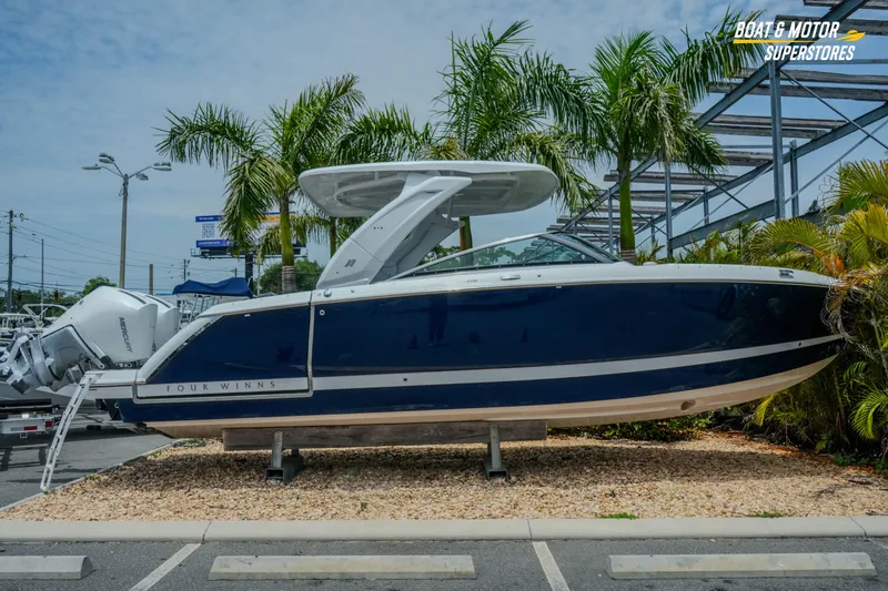Slide: The Image of 2026 Four Winns H9 OB boat displayed outdoors with palm trees in the background. - 45