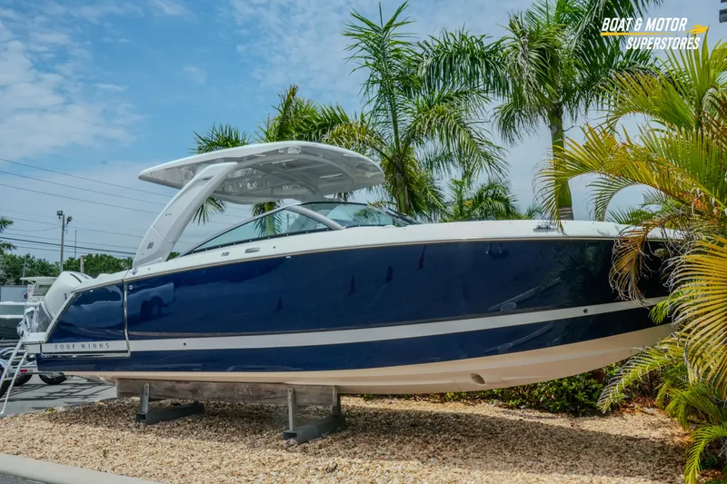 Slide: The Image of 2026 Four Winns H9 OB boat displayed outdoors with palm trees in the background. - 46