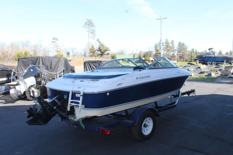 Slide: The Image of 2011 Four Winns H180 LE boat on trailer outdoors. - 6
