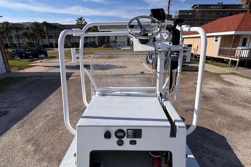 Slide: The Image of A 2006 Waterman K-18 boat console with steering wheel and controls, parked outdoors. - 12