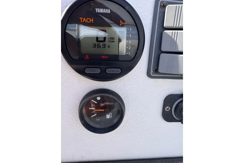 Slide: The Image of Yamaha tachometer and fuel gauge on Waterman K-18, 2006 model boat dashboard. - 14