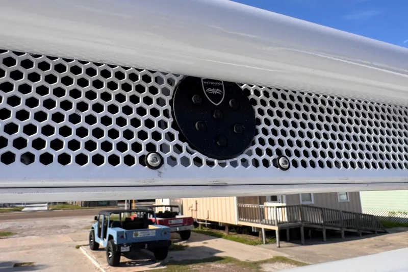 Slide: The Image of Hexagonal grille on Waterman K-18, 2006 model, with visible speaker and parked vehicles. - 16