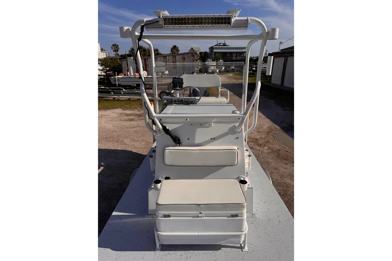 Slide: The Image of 2006 Waterman K-18 boat with seating and steering console, parked outdoors. - 21
