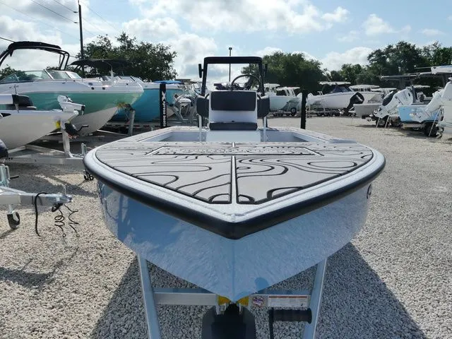 Slide: The Image of 2026 Xpress Skiff 185 boat displayed on gravel lot. - 3