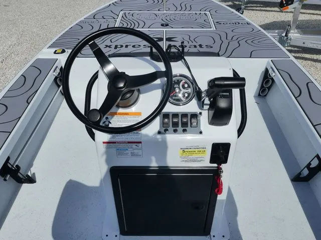 Slide: The Image of 2026 Xpress Skiff 185 boat console with steering wheel and controls. - 8