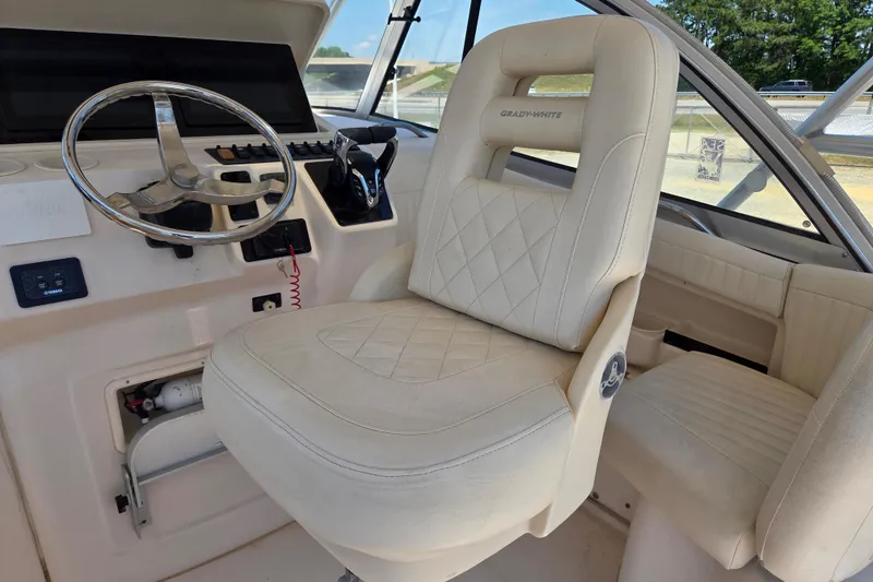Slide: The Image of 2007 Grady-White Express 305 helm with steering wheel and cushioned captain's chair. - 13