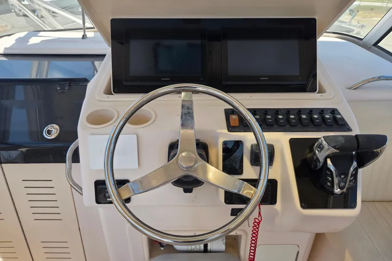 Slide: The Image of Helm of 2007 Grady-White Express 305 boat with steering wheel and dual displays. - 14