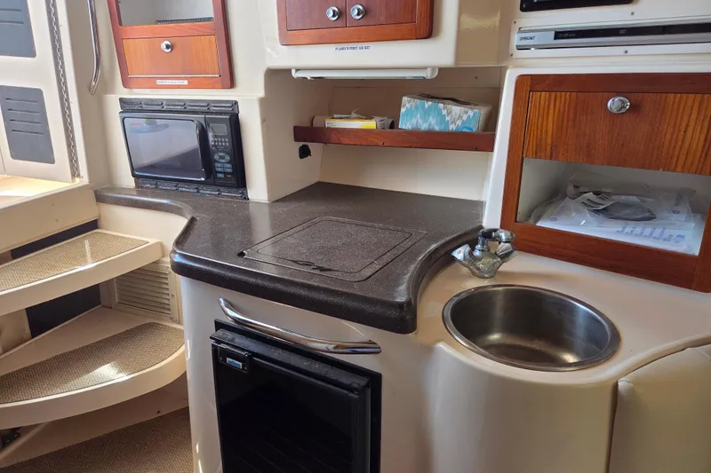 Slide: The Image of 2007 Grady-White Express 305 boat interior with kitchenette, microwave, sink, and storage cabinets. - 17
