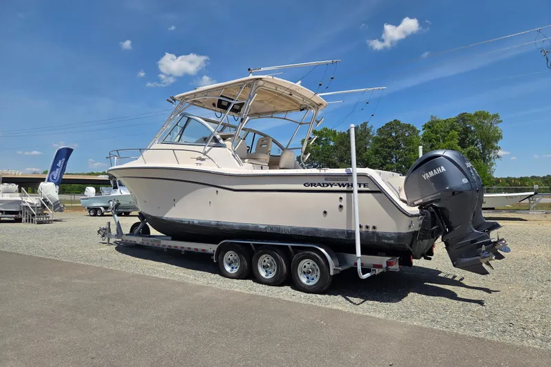 Slide: The Image of 2007 Grady-White Express 305 boat on trailer, featuring Yamaha engines, under clear blue sky. - 2