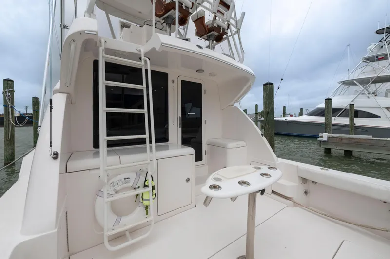 Slide: The Image of 2004 Bertram 390 Convertible yacht with ladder and fishing rod holders at dock. - 11