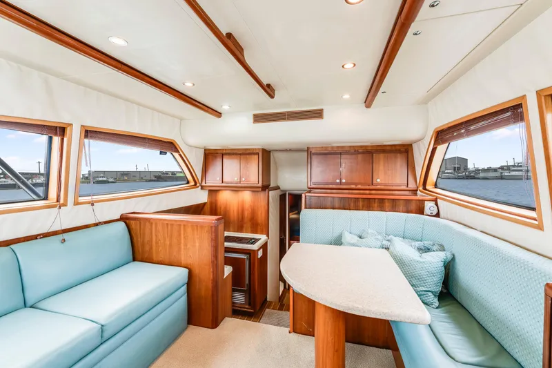 Slide: The Image of Interior of 2004 Bertram 390 Convertible yacht with elegant wood finish and plush seating. - 12