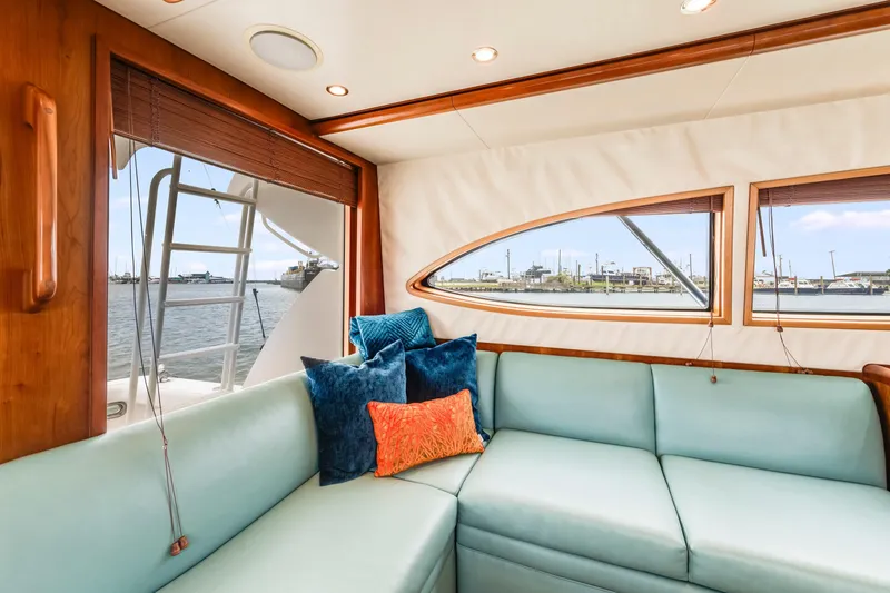 Slide: The Image of Interior of 2004 Bertram 390 Convertible yacht with plush seating and waterfront view. - 13