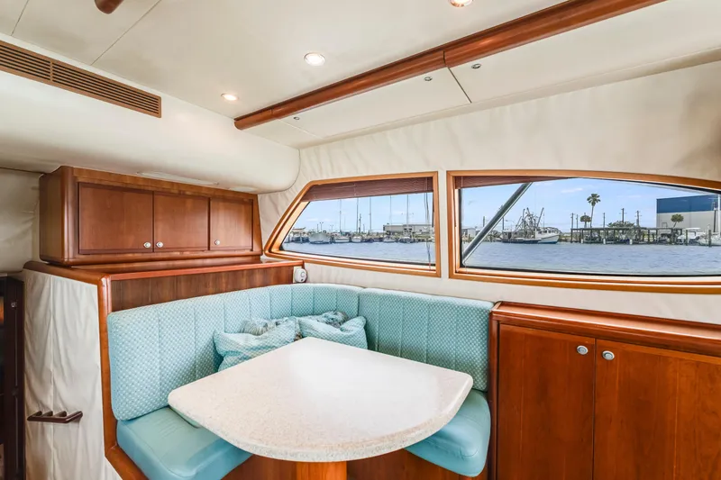 Slide: The Image of Interior of 2004 Bertram 390 Convertible yacht with cozy dining area and waterfront view. - 15