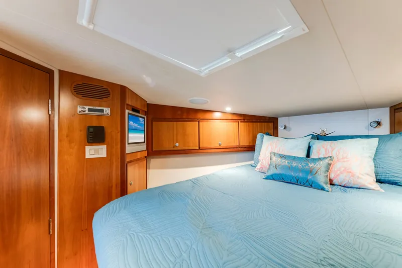 Slide: The Image of Luxurious cabin interior of 2004 Bertram 390 Convertible yacht with cozy bedding and wood accents. - 19