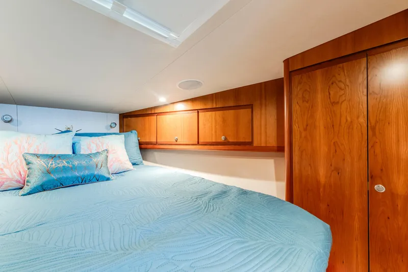 Slide: The Image of Cozy cabin interior of 2004 Bertram 390 Convertible with wooden cabinets and blue bedding. - 20