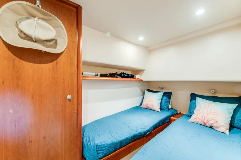 Slide: The Image of Interior of 2004 Bertram 390 Convertible with twin beds and blue bedding. - 21