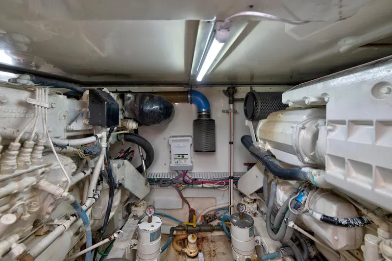 Slide: The Image of Engine room of a 2004 Bertram 390 Convertible yacht, showcasing mechanical components and wiring. - 26
