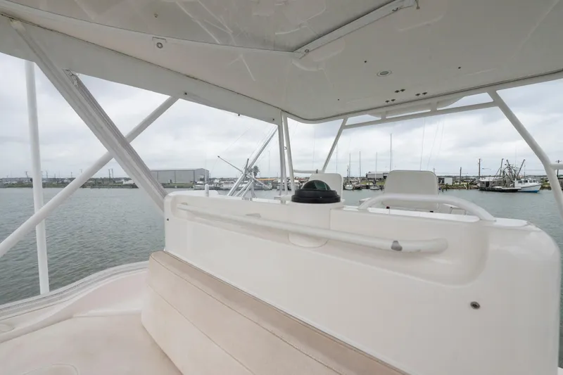 Slide: The Image of 2004 Bertram 390 Convertible boat interior with helm, overlooking marina. - 6