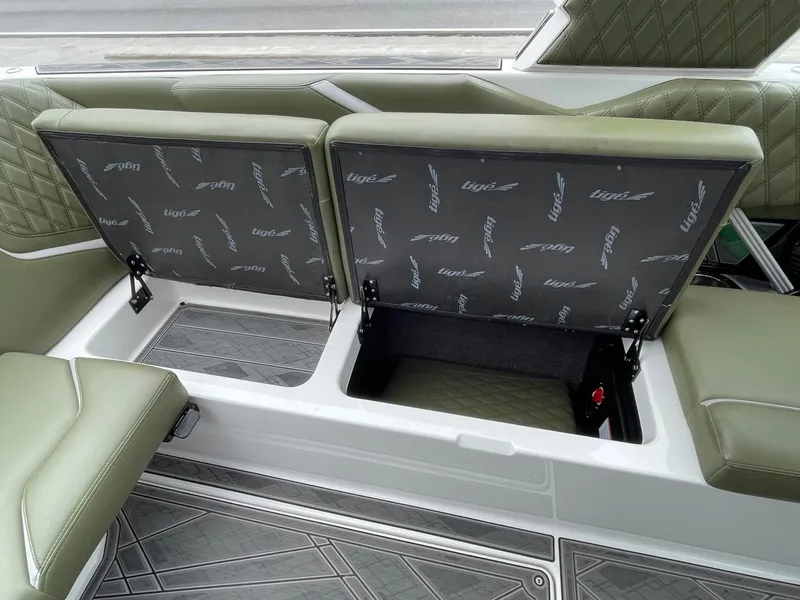 Slide: The Image of 2024 Tigé 24RZX boat with open storage compartment and green seats. - 29