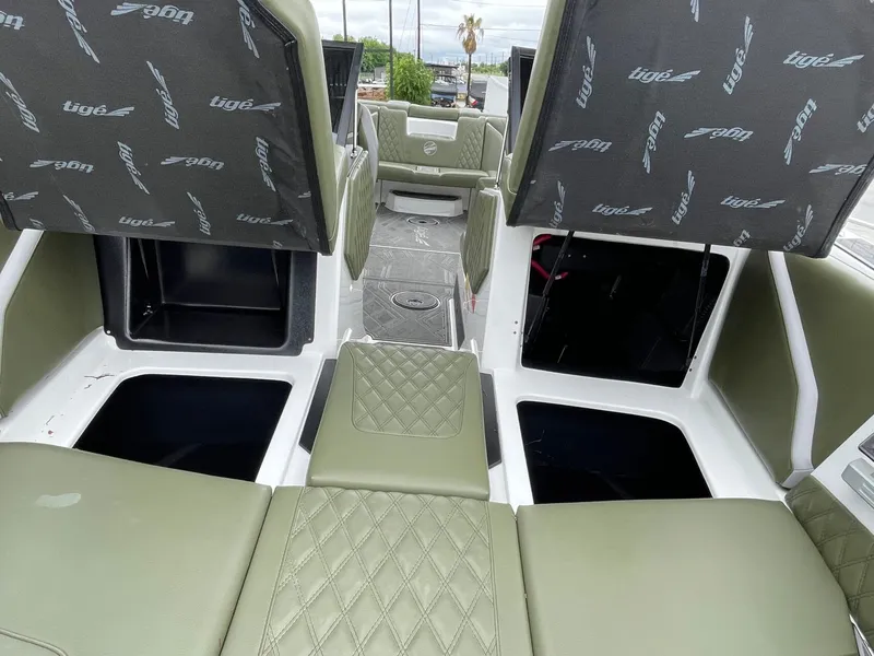 Slide: The Image of 2024 Tigé 24RZX interior with green upholstery and storage compartments. - 47