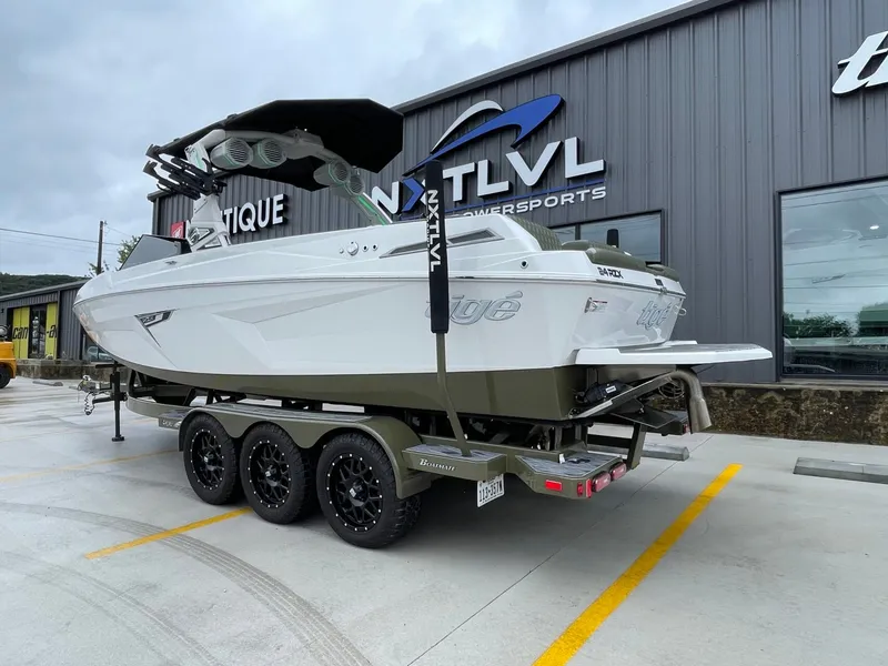 Slide: The Image of 2024 Tigé 24RZX boat on trailer outside a building. - 6