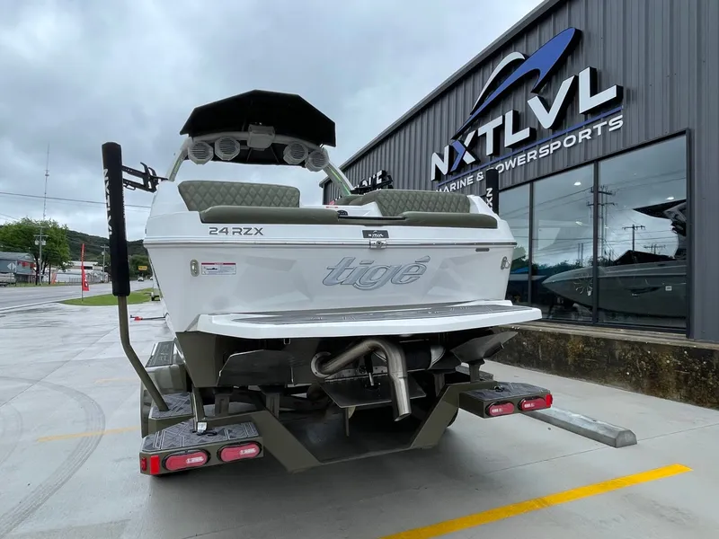 Slide: The Image of Rear view of 2024 Tigé 24RZX boat outside a showroom. - 8