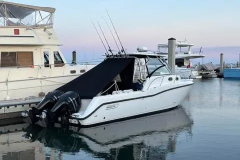 The Image of 2005 Boston Whaler 305 Conquest docked, featuring dual outboard motors and sleek design. - 0