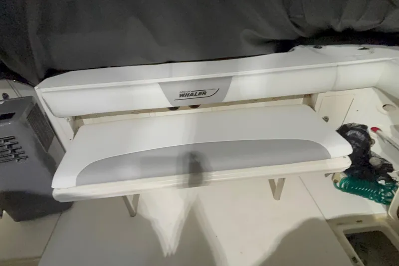 Slide: The Image of 2005 Boston Whaler 305 Conquest interior seating area with storage compartments. - 16