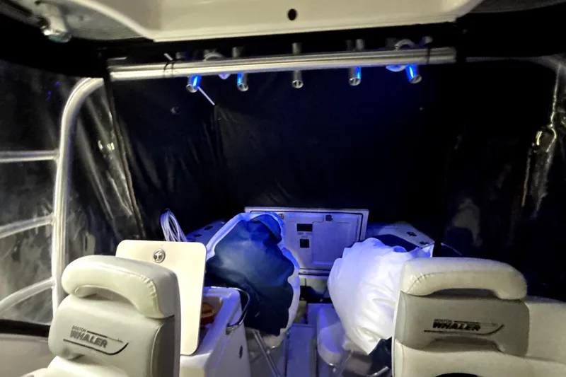 Slide: The Image of Interior of a 2005 Boston Whaler 305 Conquest boat with seating and blue lighting. - 19