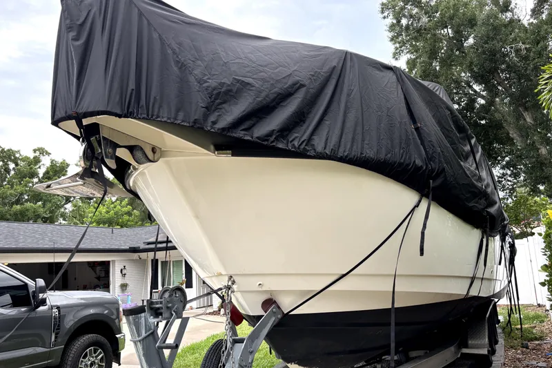 Slide: The Image of Covered 2005 Boston Whaler 305 Conquest boat on trailer, parked outdoors. - 2