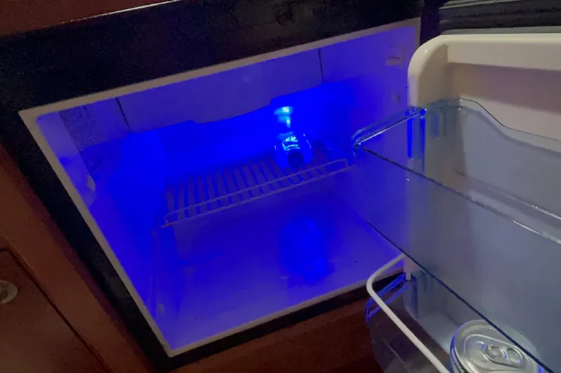 Slide: The Image of Mini fridge with blue lighting inside a 2005 Boston Whaler 305 Conquest boat. - 21