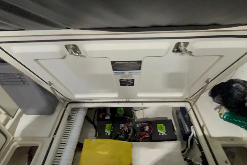 Slide: The Image of 2005 Boston Whaler 305 Conquest engine compartment with visible battery and wiring. - 33