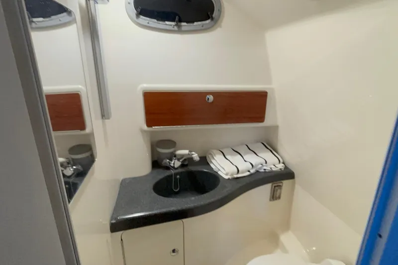 Slide: The Image of 2005 Boston Whaler 305 Conquest bathroom with sink, mirror, and storage cabinet. - 36