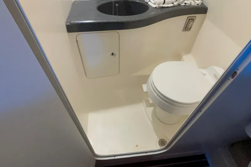 Slide: The Image of Compact bathroom in 2005 Boston Whaler 305 Conquest boat, featuring toilet and sink. - 37