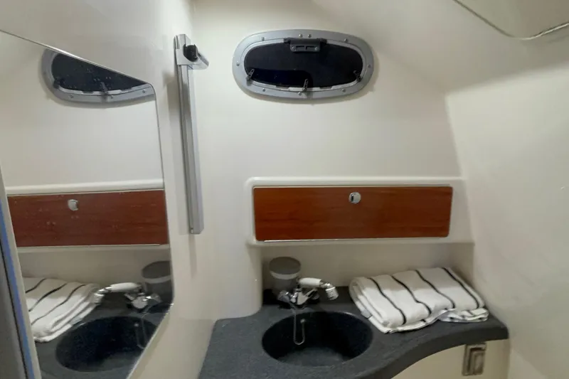 Slide: The Image of 2005 Boston Whaler 305 Conquest bathroom with sink, mirror, and storage cabinet. - 38