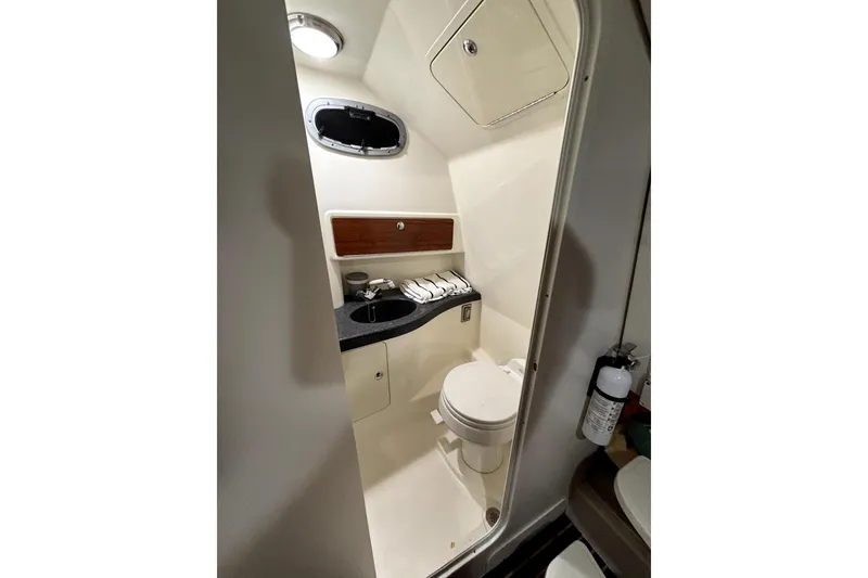 Slide: The Image of Compact bathroom in a 2005 Boston Whaler 305 Conquest boat, featuring a toilet and sink. - 41