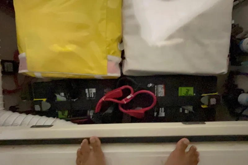 Slide: The Image of Storage compartment in a 2005 Boston Whaler 305 Conquest with bags and cables. - 42