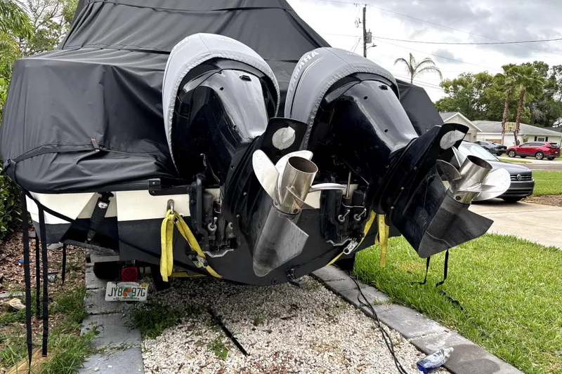 Slide: The Image of Covered 2005 Boston Whaler 305 Conquest with dual outboard motors in a residential driveway. - 5