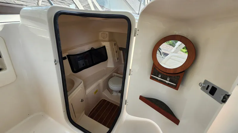 Slide: The Image of Interior of 2019 Grady-White Freedom 307 with toilet and mirror. - 13